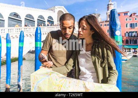 Italy, Venice, couple looking at map with Rialto bridge in background Stock Photo