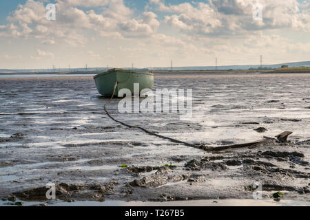 A boat in the Oare Marshes with the North Sea coast of Kent in the background, near Faversham, Kent, England, UK Stock Photo