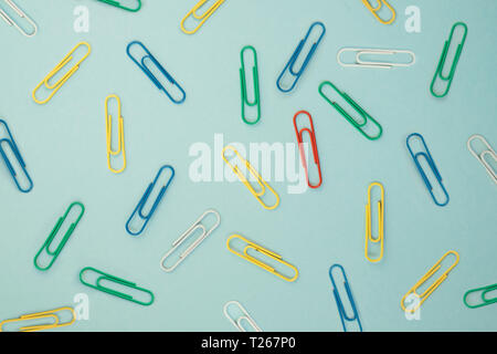 Colourful paper clips on green background Stock Photo