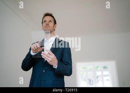 Businessman using glass touch screen in a new home Stock Photo