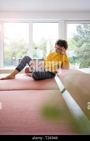 Woman using laptop on couch at home Stock Photo