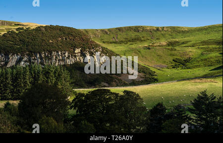 Border scenery in the Cheviot hills where Scotland joins England. Crags near Kirk Yetholm, end of the Pennine Way, with Staerough hill beyond. Stock Photo