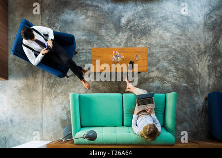 Top view of business colleagues working on laptop and smartphone in coworking space Stock Photo