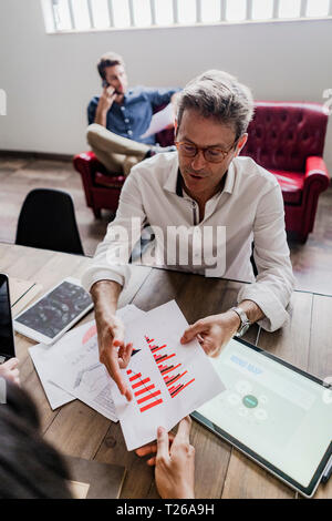 Businessman analyzing a bar chart in office Stock Photo