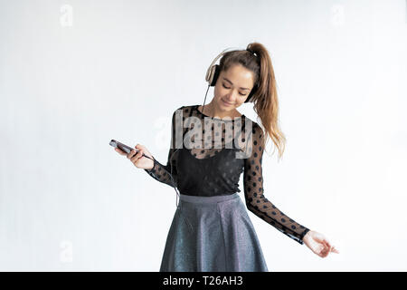 Young, elegant woman, listening music, using smartphone Stock Photo