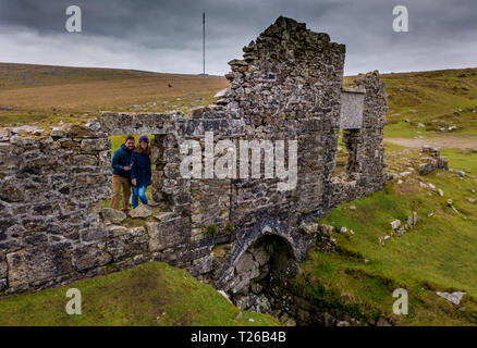 Couple look out of the window of a ruin on Dartmoor National Park, Devon, UK. Stock Photo