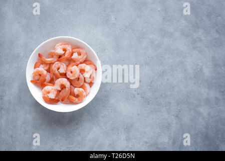 Shrimps, Prawns in bowl, top view, copy space. Fresh seafood ingredient - shrimp tails ready for cooking. Boiled prawns. Stock Photo