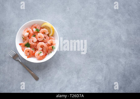 Shrimps, Prawns in bowl, top view, copy space. Fresh seafood - shrimp tails with lemon. Boiled prawns. Stock Photo