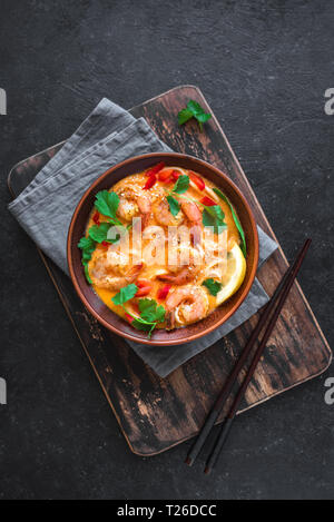 Laksa Shrimp Soup. Prawn noodle laksa soup on black background, top view, copy space. Asian Malaysian food. Stock Photo