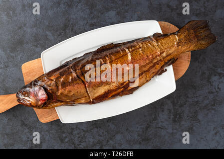 Smoked trout fish on a dark background Stock Photo