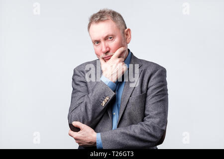 Handsome middle age man in suit has doubt expression, is confused, uncertain in future Stock Photo