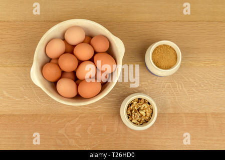 arm Fresh Organic Free Range Eggs, Walnuts and Brown Sugar in Bowls. Overhead View. Farm to Table Stock Photo