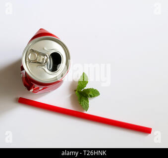 Crumpled aluminum can, red drinking straw and mint leaves isolated on white background. Top view Stock Photo