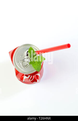 Crumpled aluminum can, red drinking straw and mint leaves isolated on white background. Top view Stock Photo