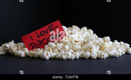 Popcorn with tag - I love popcorn isolated on dark background Stock Photo