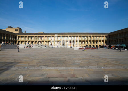 View looking across the open square towards the North Wall of the quadrangle of restored The Piece Hall. Sunny / sun & blue sky. The sunlit Northwall is in the background. Halifax, West Yorkshire, England UK Stock Photo