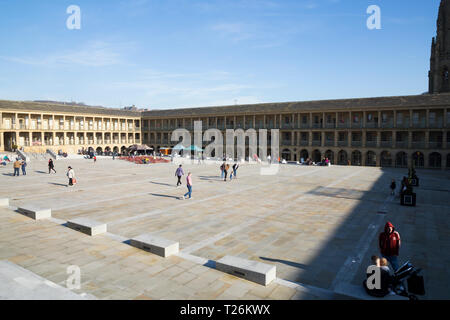 The central square area and quadrangle of The Piece Hall. Sunny / sun & blue sky. Halifax, West Yorkshire, UK. The North wall is lit by sunlight; the east wall is in shade. (106) Stock Photo