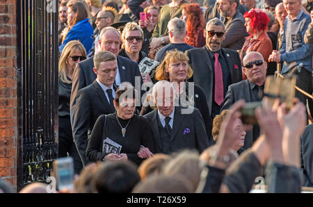 Essex, UK. 30th March 2019. The  funeral of Prodigy singer Keith Flint at St Marys Church in Bocking,  Essex today. Mourners leave the service and band members Liam Howlett and Leeroy Thornhill can be seen following Keith’s father Clive Flint out of the front gates of the church. Credit: Phil Rees/Alamy Live News Stock Photo
