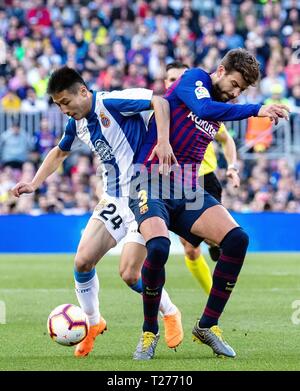 Barcelona, Spain. 30th Mar, 2019. FC Barcelona's Gerard Pique (R) vies with Espanyol's Wu Lei during a Spanish league match between FC Barcelona and RCD Espanyol in Barcelona, Spain, on March 30, 2019. FC Barcelona won 2-0. Credit: Joan Gosa/Xinhua/Alamy Live News Stock Photo