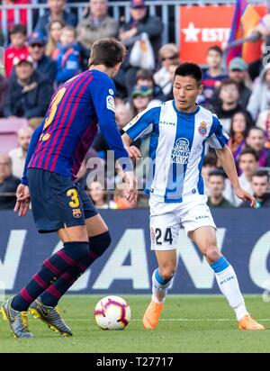 Barcelona, Spain. 30th Mar, 2019. FC Barcelona's Gerard Pique (L) vies with Espanyol's Wu Lei during a Spanish league match between FC Barcelona and RCD Espanyol in Barcelona, Spain, on March 30, 2019. FC Barcelona won 2-0. Credit: Joan Gosa/Xinhua/Alamy Live News Stock Photo