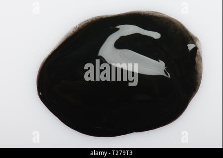 Black ink paint drop on white paper background Stock Photo