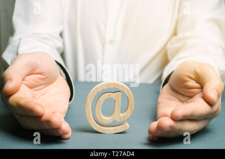 A man wraps his hands around an e-mail and internet stick figure. The concept of saving the internet is open and independent. Online censorship, copyr Stock Photo