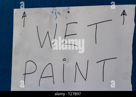 Hand made wet paint sign on blue background Stock Photo