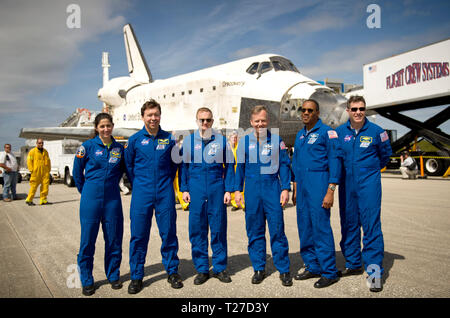 NASA Astronauts and STS-133 mission crew members, from left, Mission Specialists Nicole Stott, Michael Barratt, Pilot Eric Boe, Commander Steve Lindsey, Mission Specialists Alvin Drew, and Steve Bowen pose for a photograph in front of the space shuttle Discovery after they landed, Wednesday, March 9, 2011, at Kennedy Space Center in Cape Canaveral, Fla., completing Discovery's 39th and final flight. Stock Photo