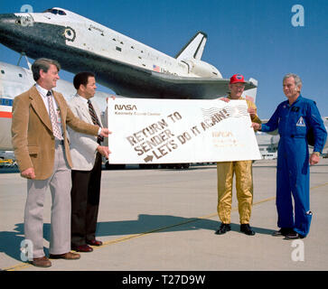 After completing it's first orbital mission with a landing at Edwards Air Force Base on April 14, 1981, Space Shuttle Columbia received a humorous sendoff before it's ferry flight atop a modified 747 back to the Kennedy Space Center in Florida. Holding the sign are, left to right: Melvin Burke, DFRC Orbital Flight Test (OFT) Program Manager; Isaac 'Ike' Gillam, DFRC Center Director; Fitzhugh 'Fitz' L. Fulton Jr., NASA DFRC 747 SCA Pilot; and Donald K. 'Deke' Slayton, JSC OFT Project Manager. Stock Photo