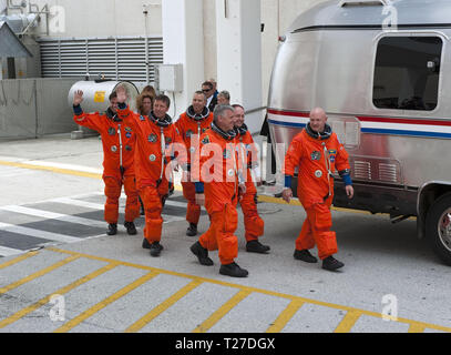 CAPE CANAVERAL, Fla. -- Space shuttle Endeavour's six STS-134 astronauts, dressed in their orange launch-and-entry suits, wave to news media and other spectators as they walk toward the Astrovan parked in front of the Operations and Checkout Building at NASA's Kennedy Space Center in Florida. Leading the way is Commander Mark Kelly, followed by crewmates Greg H. Johnson, Michael Fincke, Andrew Feustel, Roberto Vittori with the European Space Agency and Greg Chamitoff. Stock Photo