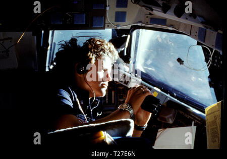 (14 Oct. 1984) --- Kathryn D. Sullivan, 41-G mission specialist, uses a pair of binoculars to do some magnified viewing Stock Photo