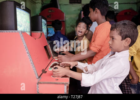 Boys play old style arcade video games in Geneva Camp, stranded
