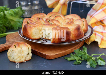 Yeast pie with herbs and garlic located on a dark background Stock Photo