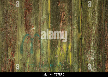 Planks of wood with peeled painting in a door forming an odd background at Salamanca. With medieval buildings is also an university city from Spain. Stock Photo