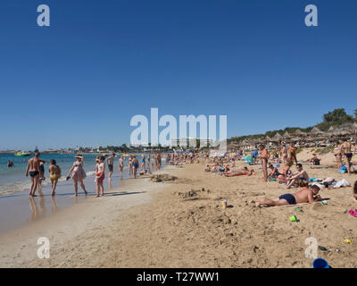 Blue sky, sandy beach, warm Mediterranean sea and a crowd of holiday makers in the sun, a normal day in Ayia Napa Cyprus Stock Photo