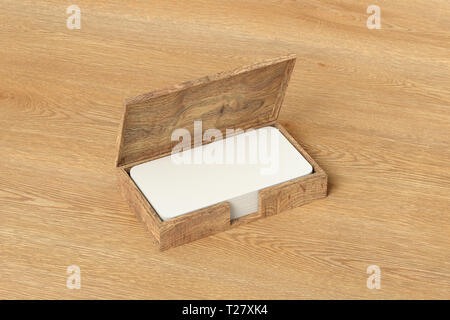 Wooden business card box holder with blank business  cards with round corners in stack on wooden background Stock Photo