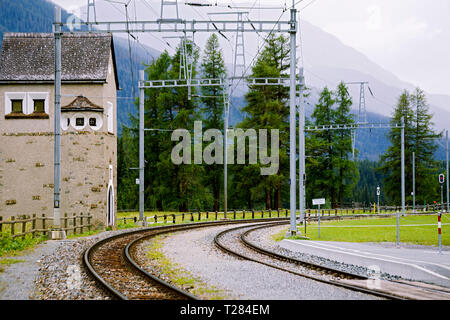 Old narrow gauge railway in the valley of the Alps among the trees in cloudy weather. Stock Photo