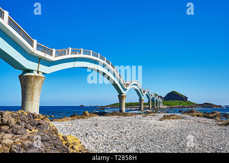 Beautiful scenic of Sanxiantai arch bridge with blue ocean with Three saint island in behind at Chenggong district in Taitung city, Taiwan. Stock Photo