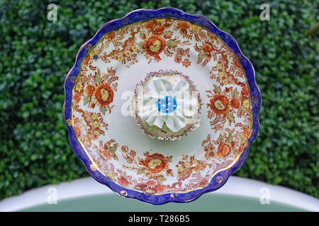 Bone china saucer and daisy cupcake Stock Photo