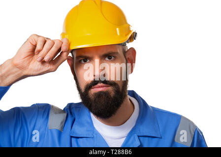 Builder in hard hat, foreman or repairman touching his helmet. Bearded man worker with beard in hard hat. Portrait architect builder, civil engineer w Stock Photo