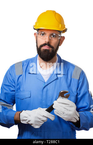 Repair, construction, building, people and maintenance concept- man, a worker, in a yellow helmet, transparent safety glasses and blue uniform holding Stock Photo