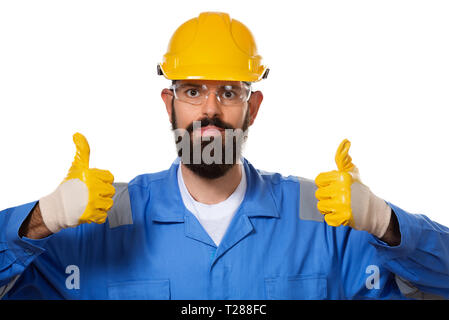 Close up portrait of handsome hipster bearded builder in hard hat raising his thumbs up in working gloves, concept of success and approval, ok gesture Stock Photo