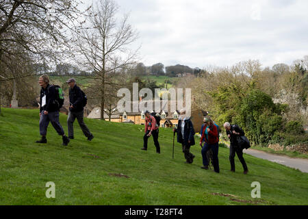 A walking group in Ilmington village in spring, Warwickshire, England, UK Stock Photo