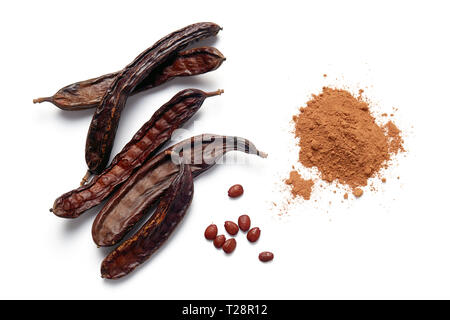 Carob bean pods, seeds and powder on white background Stock Photo
