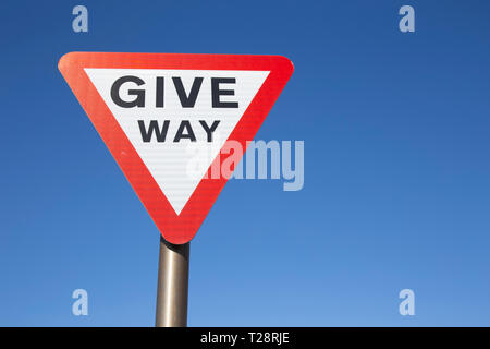 Give Way Sign Against A Blue Sky With White Clouds Stock Photo - Alamy