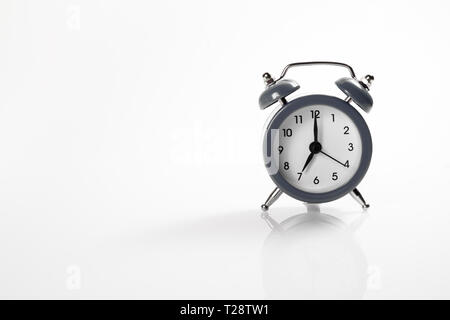 Dark alarm clock with shadow and space for your presentation text. Isolated on white background. Stock Photo
