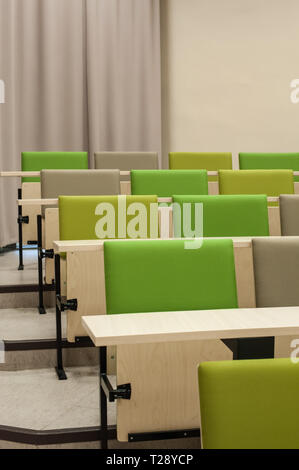 Colourful green seat covers in a university lecture theatre. Stock Photo