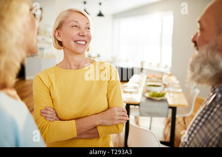Positive friends chatting in dining room Stock Photo