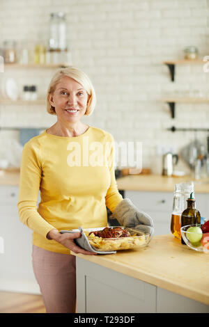 Mature woman satisfied with her cooked dish Stock Photo