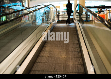 Person rush on escalator motion blurred in the background Stock Photo
